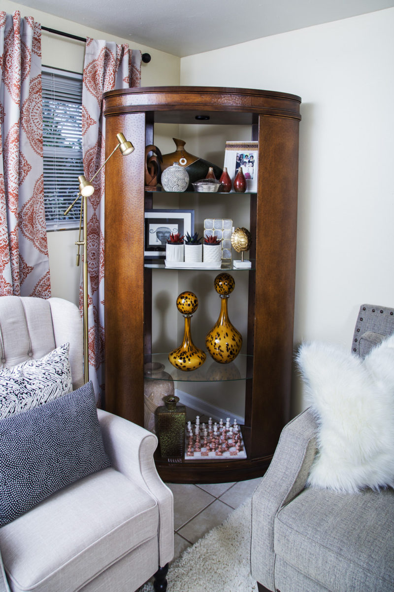 neutral living room | cream recliner | gold studs pillow | leather bookcase | neutral with pop of orange | britt smith photography