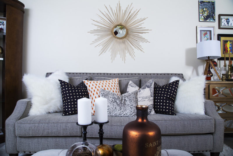 neutral living room | cream recliner | gold studs pillow | leather bookcase | neutral with pop of orange | gold sunburst mirror | eclectic bar cart | britt smith photography