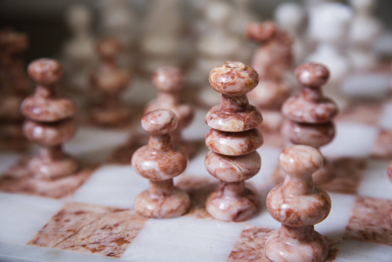 neutral living room | bookcase styling | peach chess board set | pink chess board set | coral chess board set | leather bookcase | britt smith photography