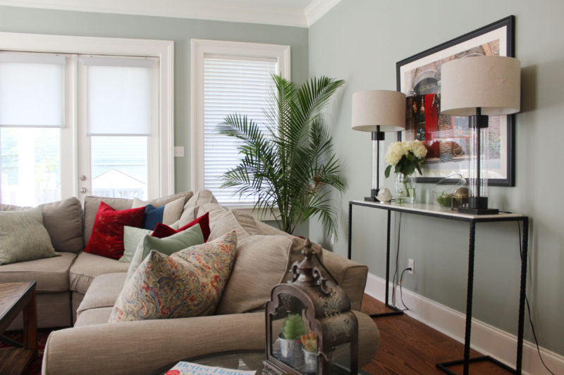 red and blue transitional living room | whitney j decor | new orleans homes | nola decor | red pillows | green walls | sherwin williams oyster gray on the walls | vintage red rug | pottery barn sectional | convertible coffee table | new orleans interior designer | new orleans decorator | new orleans blogger | nola interior designer | nola decorator | nola blogger
