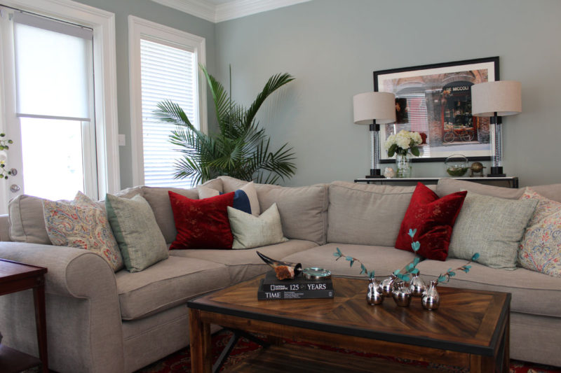 red and blue transitional living room | whitney j decor | new orleans homes | nola decor | red pillows | green walls | sherwin williams oyster gray on the walls | vintage red rug | pottery barn sectional | convertible coffee table | new orleans interior designer | new orleans decorator | new orleans blogger | nola interior designer | nola decorator | nola blogger