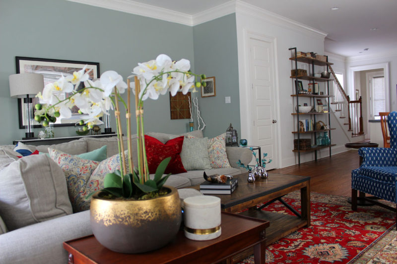 red and blue transitional living room | whitney j decor | new orleans homes | nola decor | red pillows | green walls | sherwin williams oyster gray on the walls | vintage red rug | pottery barn sectional | convertible coffee table | new orleans interior designer | new orleans decorator | new orleans blogger | nola interior designer | nola decorator | nola blogger