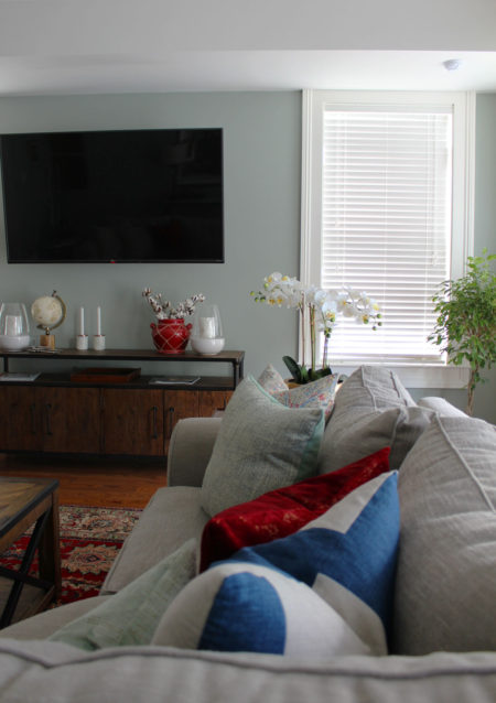 red and blue transitional living room | whitney j decor | new orleans homes | nola decor | red pillows | green walls | sherwin williams oyster gray on the walls | vintage red rug | pottery barn sectional | convertible coffee table | new orleans interior designer | new orleans decorator | new orleans blogger | nola interior designer | nola decorator | nola blogger