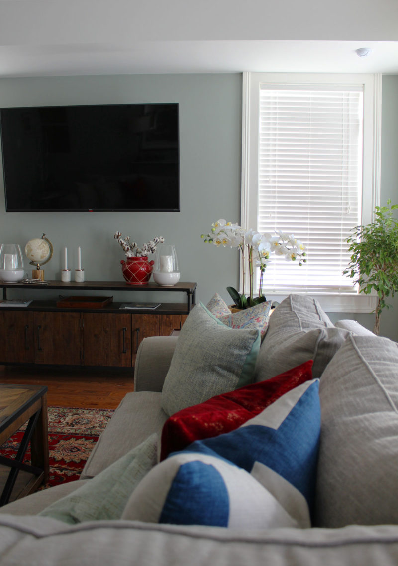 red and blue transitional living room | whitney j decor | new orleans homes | nola decor | red pillows | green walls | sherwin williams oyster gray on the walls | vintage red rug | pottery barn sectional | convertible coffee table | new orleans interior designer | new orleans decorator | new orleans blogger | nola interior designer | nola decorator | nola blogger