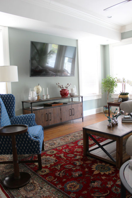 red and blue transitional living room | whitney j decor | new orleans homes | nola decor | red pillows | green walls | sherwin williams oyster gray on the walls | vintage red rug | pottery barn sectional | convertible coffee table | new orleans interior designer | new orleans decorator | new orleans blogger | nola interior designer | nola decorator | nola blogger
