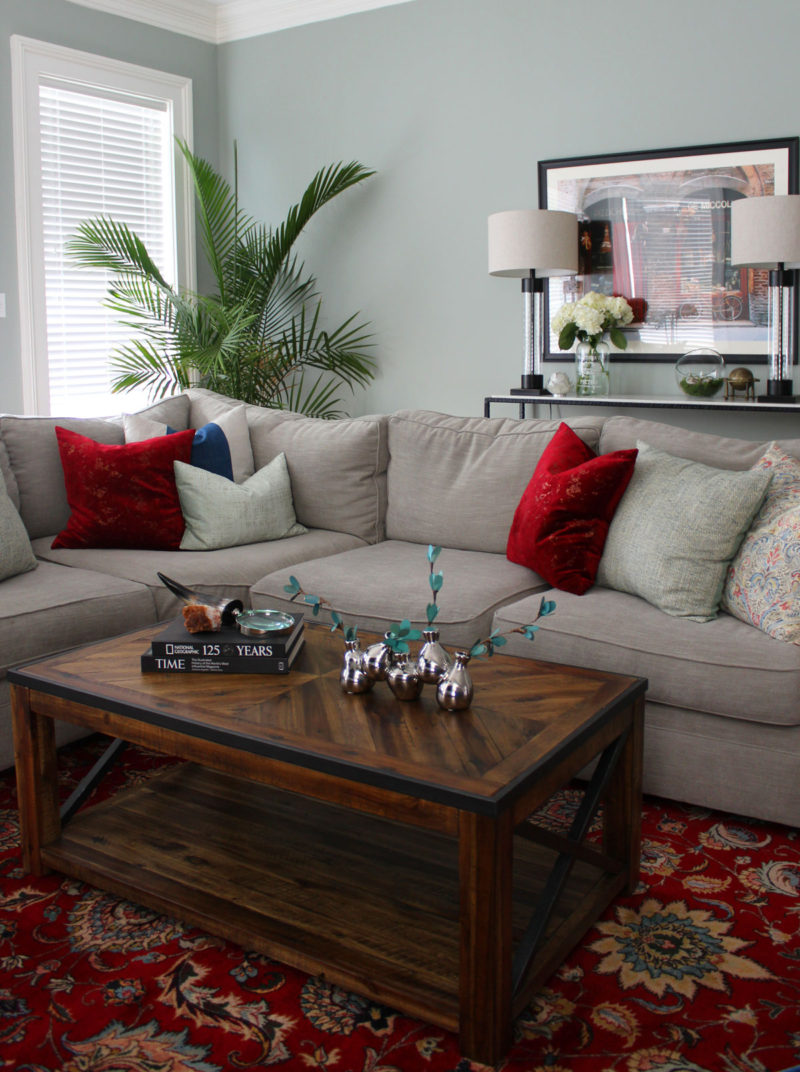 red and blue transitional living room | whitney j decor | new orleans homes | nola decor | red pillows | green walls | sherwin williams oyster gray on the walls | vintage red rug | pottery barn sectional | convertible coffee table | new orleans interior designer | new orleans decorator | new orleans blogger | nola interior designer | nola decorator | nola blogger