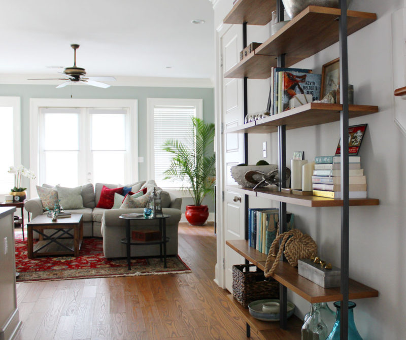 red and blue transitional living room | whitney j decor | new orleans homes | nola decor | red pillows | green walls | sherwin williams oyster gray on the walls | vintage red rug | pottery barn sectional | convertible coffee table | new orleans interior designer | new orleans decorator | new orleans blogger | nola interior designer | nola decorator | nola blogger