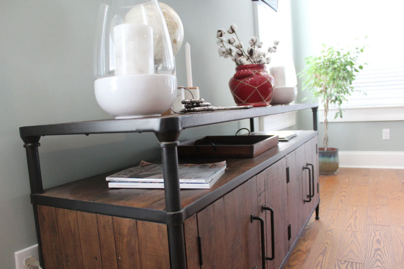 red and blue transitional living room | whitney j decor | new orleans homes | nola decor | red pillows | green walls | sherwin williams oyster gray on the walls | vintage red rug | pottery barn sectional | convertible coffee table | new orleans interior designer | new orleans decorator | new orleans blogger | nola interior designer | nola decorator | nola blogger