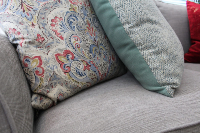 red and blue transitional living room | whitney j decor | new orleans homes | nola decor | red pillows | green walls | sherwin williams oyster gray on the walls | vintage red rug | pottery barn sectional | convertible coffee table | new orleans interior designer | new orleans decorator | new orleans blogger | nola interior designer | nola decorator | nola blogger
