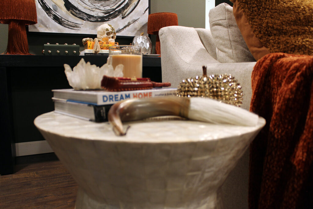 fall decor inspiration - burnt orange throw with capiz table and black table and white art in the background