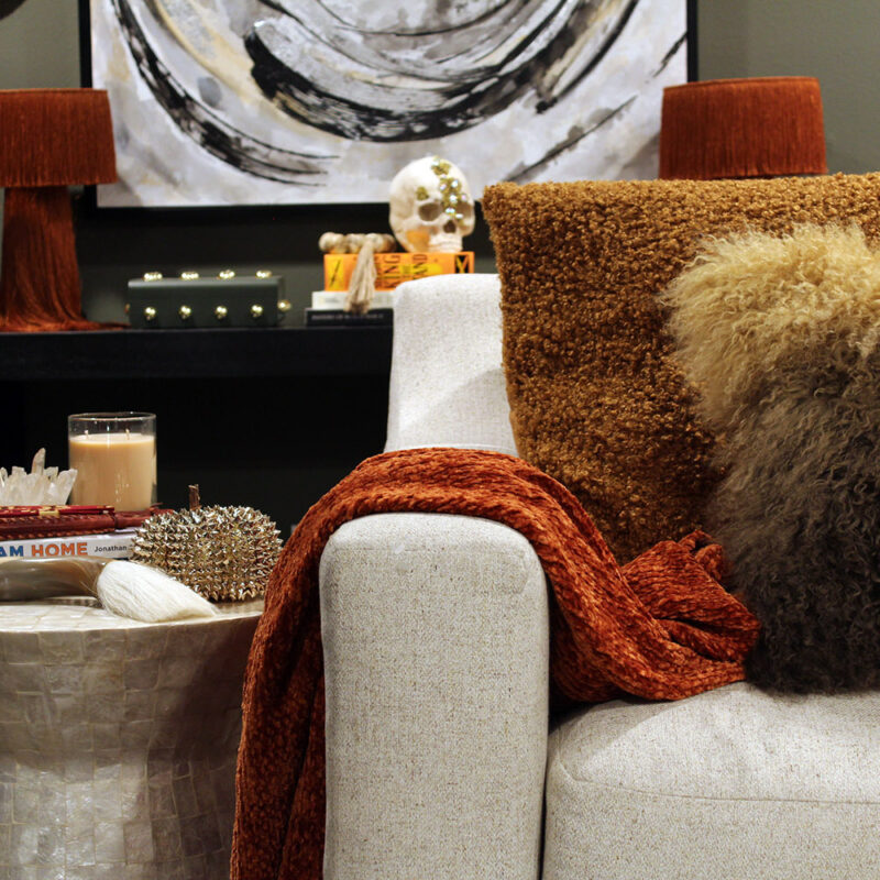 fall decor inspiration - burnt orange throw with capiz table and black table and white art in the background