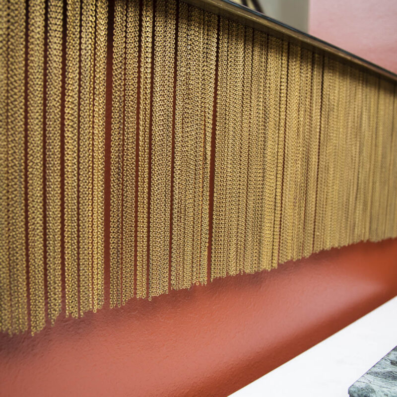 closeup photo of tassel detail on wall mirror | bold red sitting room