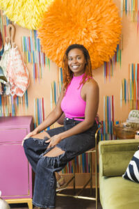 Portrait of Alexa Jones, project manager at Whitney J Decor, standing in a bright interior setting and smiling confidently, reflecting her role as the operational force behind the studio.
